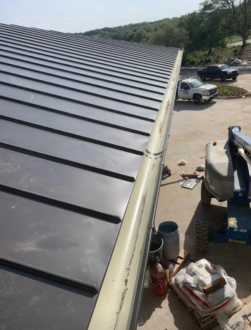 Standing seam panel and gutter detail on a metal roofing jobsite in Arkansas City